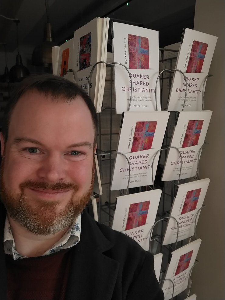 Mark standing in front of a display of his book 